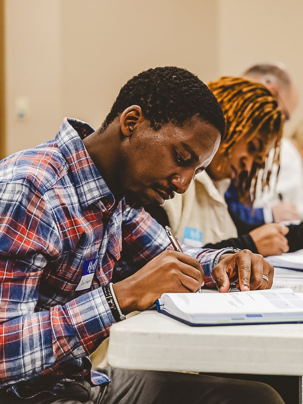 A participant taking notes in a workbook