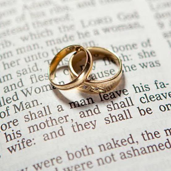 Two wedding rings resting on an open Bible