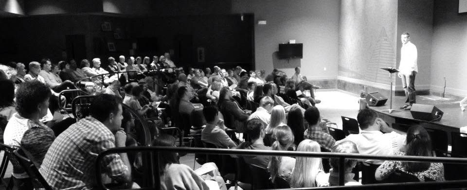A speaker addressing a full auditorium during a marriage presentation