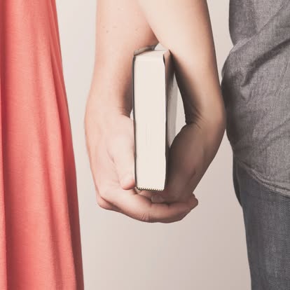 A couple holding a book together